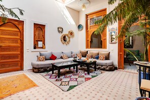 A cozy living room with a sofa, coffee table, and decorative rugs. - riadjenan (Marrakech)