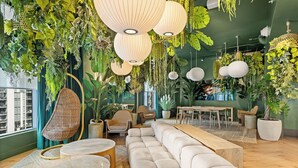 Um interior moderno com sofá modular, plantas penduradas e área de jantar.