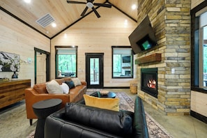 Ein Holzblockhaus mit Kamin aus Stein, Holzwänden und einer Ledersofa.