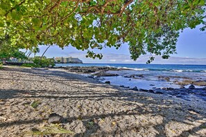 A beach with rocky shoreline, a cruise ship in the background, and lush greenery overhead. - Kailua-kona Group Getaway: 5-unit Bundle! (Kailua-Kona)