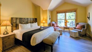 A bedroom with a bed, bedside tables, a bench, a chair, a window, and a lamp. - Private Balcony | King Bed | Near Trails (Keystone)