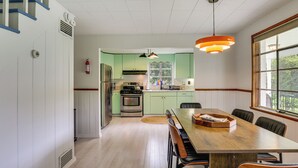 A kitchen with a dining area, a stove, refrigerator, and a window with a view. - Lakefront Bliss in Mahopac! Charming Home w/ Dock (Mahopac)