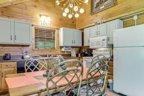 A wooden interior with a dining table, chairs, a refrigerator, and kitchen appliances. - 4 Mi to Dollywood! Family Escape w/ Air Hockey! (Sevierville)