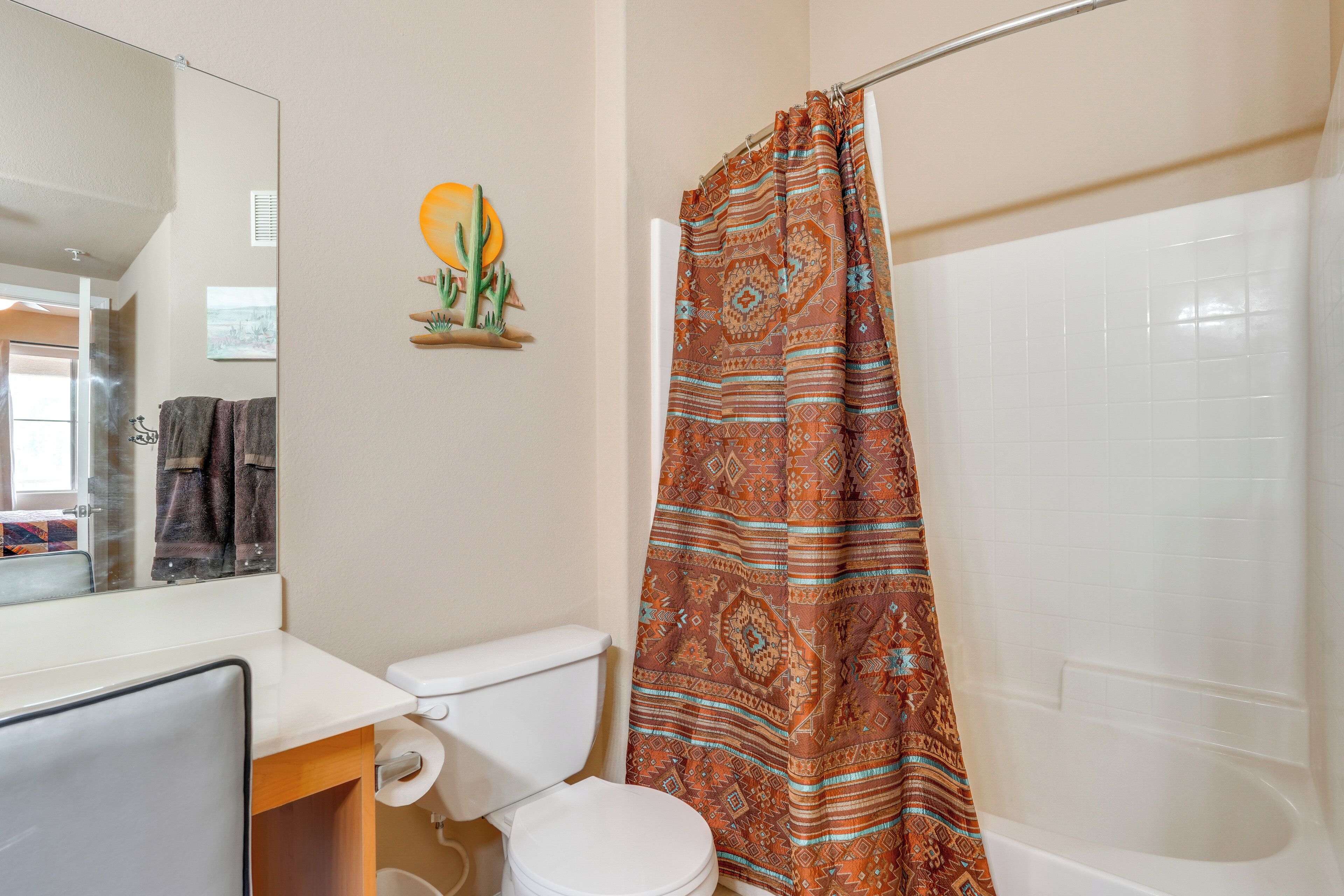 A bathroom with a toilet, a shower curtain, and a bathtub.