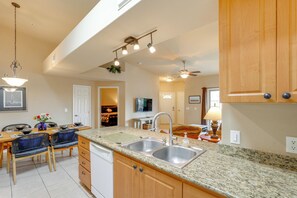 A kitchen with granite countertops, stainless steel sink, wooden cabinets, and a ceiling fan. - 2 Resort-style Pools! Condo Near Mesa Market Place (Mesa)