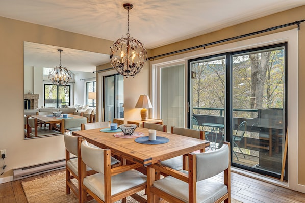 A dining area with a wooden table, chairs, and a chandelier. - Hike, Explore & Unwind: All-season Lincoln Retreat (Lincoln)