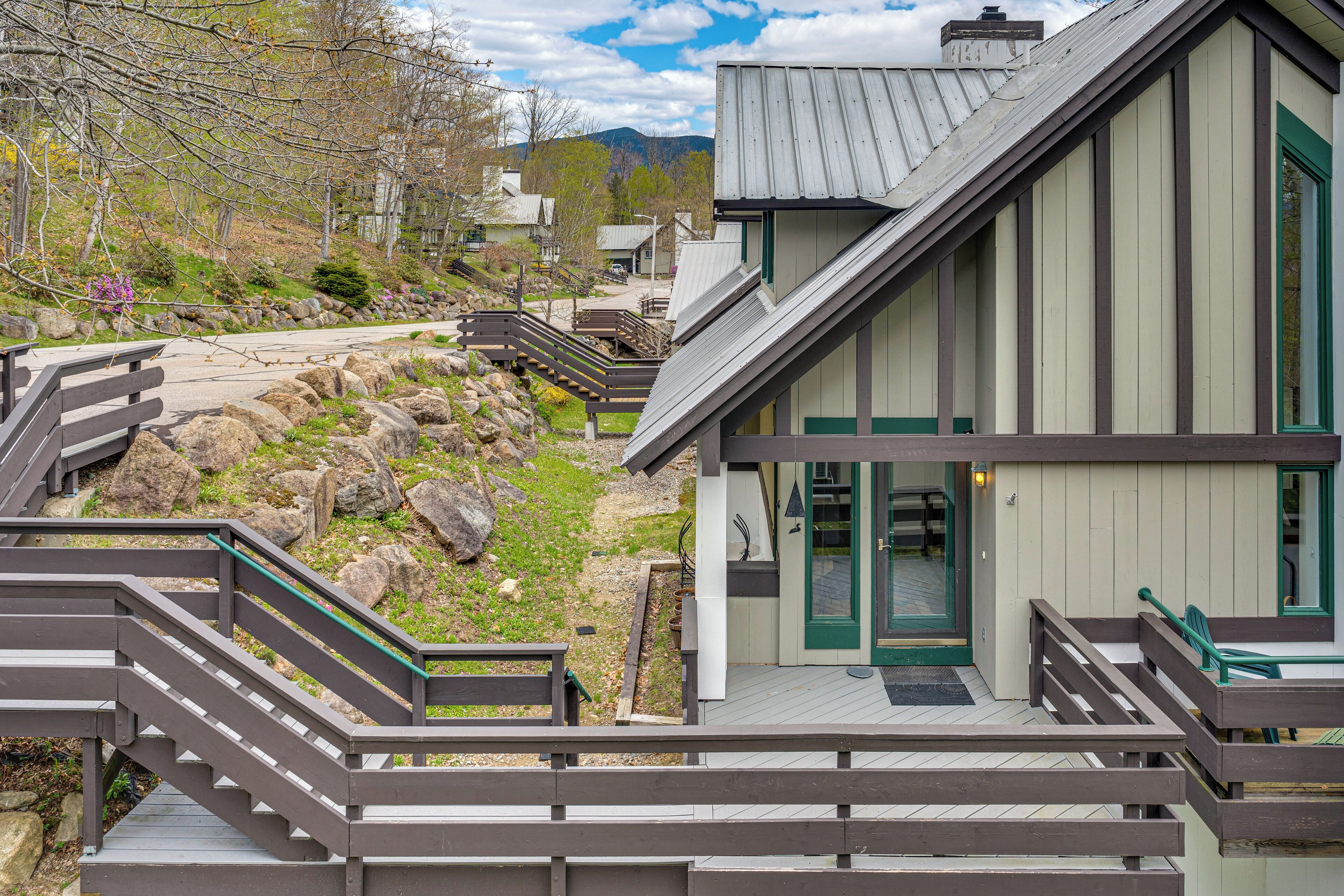 A modern building with a sloped roof, a wooden staircase, and a view of a natural landscape.