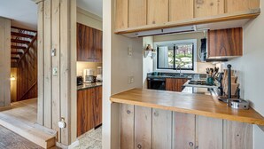 Una cocina con armarios de madera, una encimera y un ventanal.
