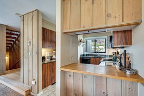A kitchen with wooden cabinets, a countertop, and a window. - Hike, Explore & Unwind: All-season Lincoln Retreat (Lincoln)