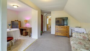 A room with a dining table, a sofa, a TV, and a wooden dresser. - Walk to Falls, Casino! Niagara Family Home w/ Yard (Niagara Falls)