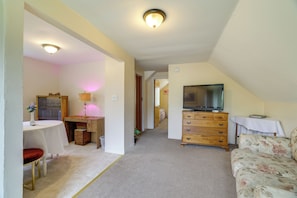 A room with a dining table, a sofa, a TV, and a wooden dresser. - Walk to Falls, Casino! Niagara Family Home w/ Yard (Niagara Falls)