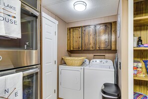 A compact laundry area with a washing machine, a dryer, and a small stool. - Private Dock & Furnished Deck! Cozy Belfair Escape (Belfair)