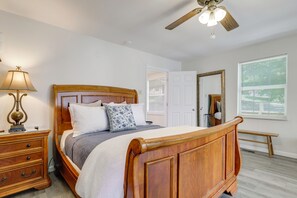 A bedroom with a wooden bed, a nightstand, a lamp, a ceiling fan, a window with blinds, and a door. - Douglas Lake Gem on Private Cove w/ Amazing Views! (Dandridge)