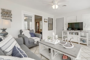 A living room with a grey sofa, a coffee table with decorative swans, a television, and a white cabinet. - Douglas Lake Gem on Private Cove w/ Amazing Views! (Dandridge)
