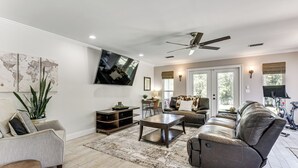 Ein Wohnzimmer mit einer Couch, einem Couchtisch, einem Fernseher und einer Weltkarte an der Wand.