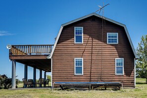 Ein hölzernes Bauernhaus mit Balkon, Satellitenschüssel und Trampolin.