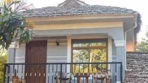 A two-story house with a balcony, a garage, and potted plants. - Ukarimu Hosts (Arusha)