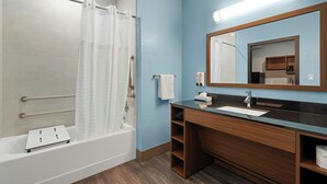 Un baño con bañera, lavabo, espejo y cortina de ducha.