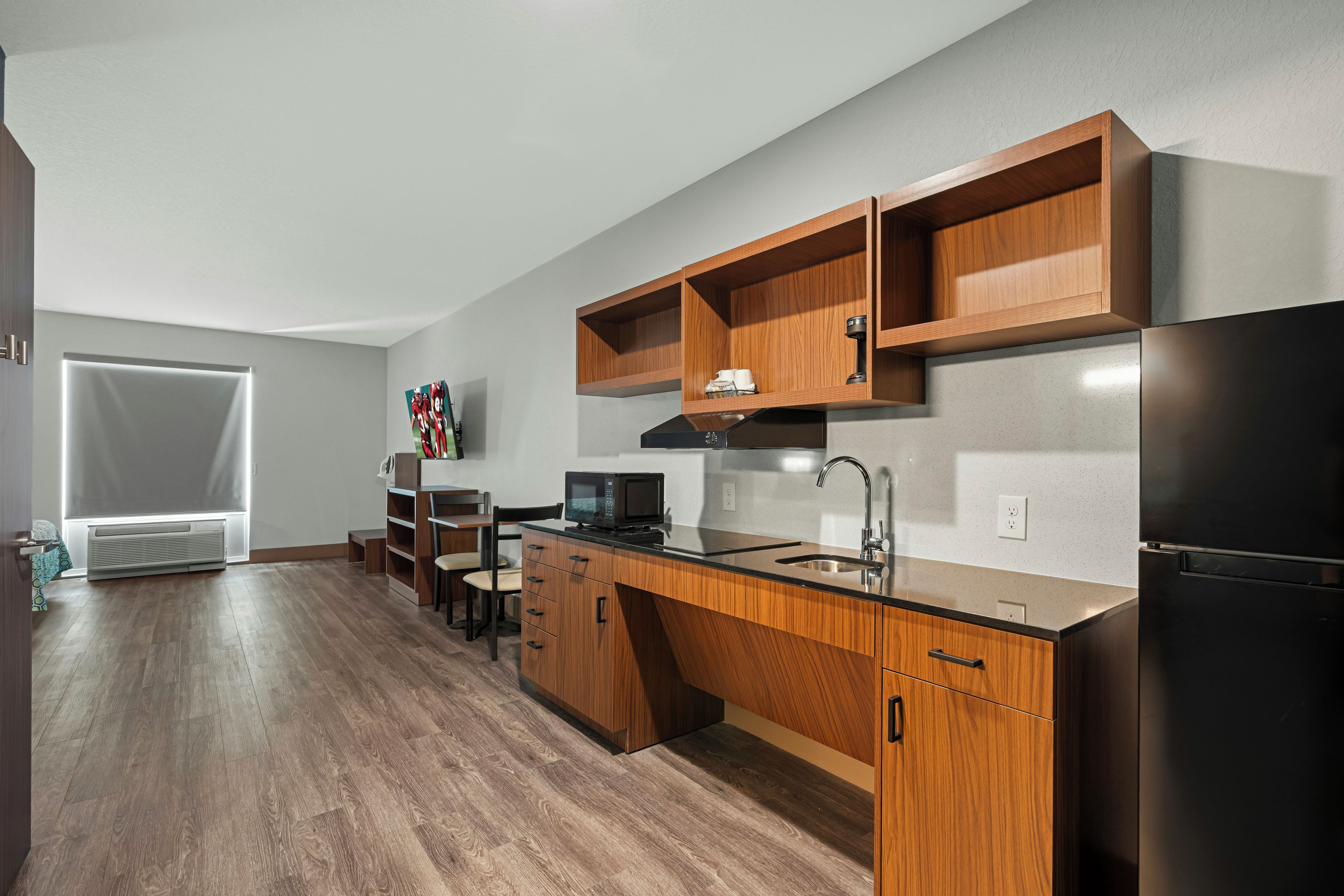 Una cocina moderna con armarios de madera, un refrigerador de acero inoxidable y un microondas.