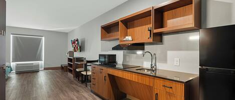 Una cocina moderna con armarios de madera, un refrigerador de acero inoxidable y un microondas.