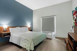 Une chambre d’hôtel équipée d’un lit, de tables de chevet, d’un téléviseur et d’un radiateur fixé au mur.