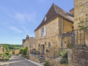 A stone building with a tiled roof, a gated entrance, and a small porch. - Authentic family home near village - 6 ppl (Domme)