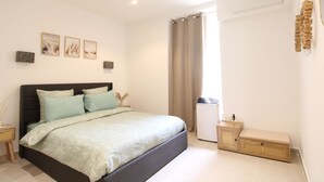 A bedroom with a bed, a bedside table, a small cabinet, and a window with curtains. - Calm Elegant Apartment in the Heart of Nice (Nice)
