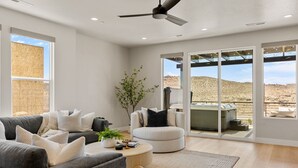 Ein modernes Wohnzimmer mit einem grauen Sofa, einem runden Couchtisch und einem weißen Sessel.