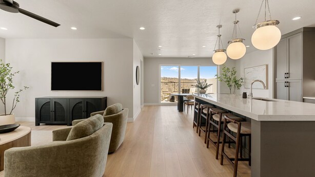 Eine moderne Küche mit Bar, Essbereich und Wohnbereich inklusive Sofa und Fernseher.