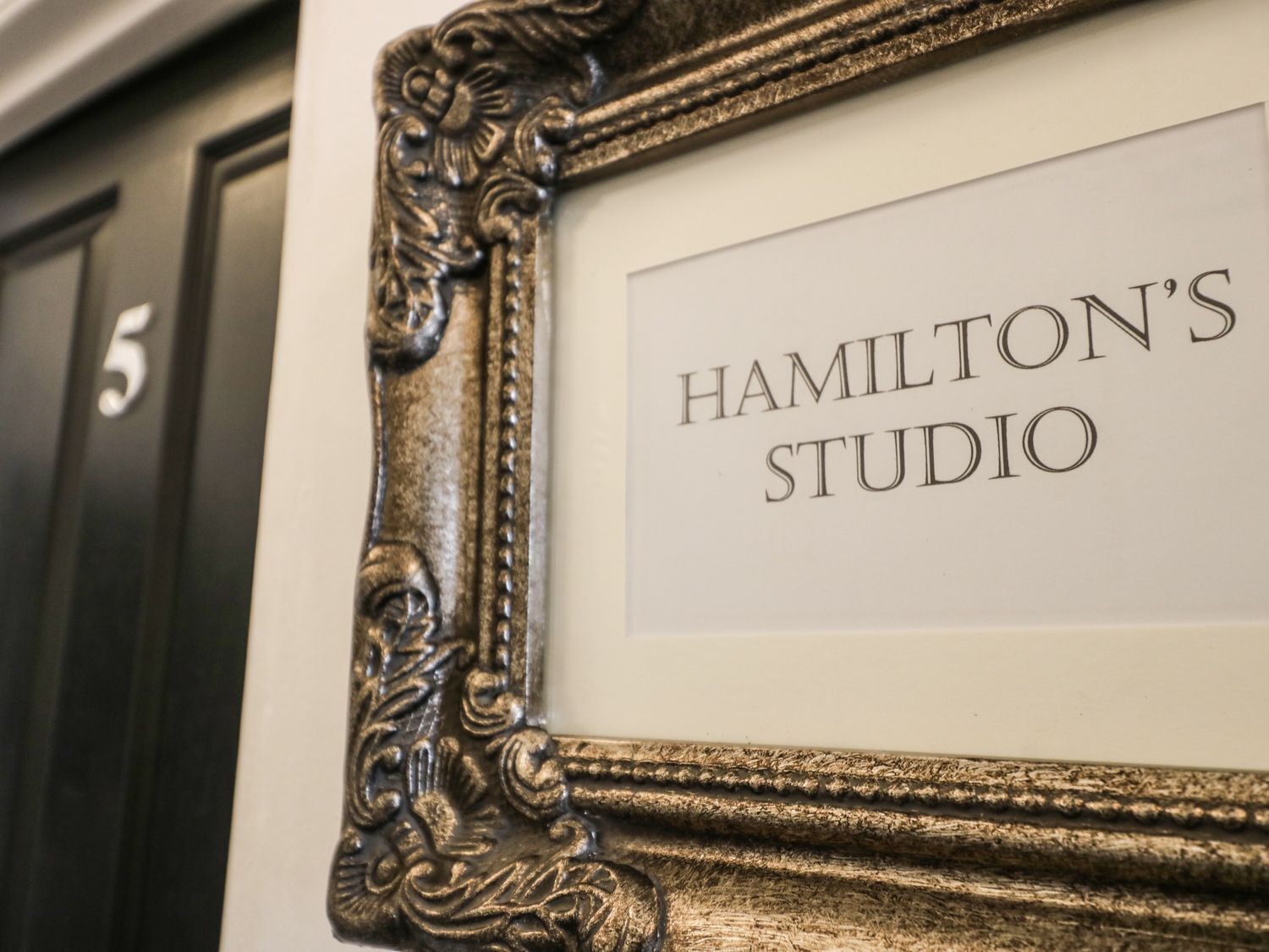 A framed sign with 'HAMILTON'S STUDIO' text.