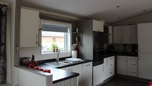 Una cocina moderna con ventana, electrodomésticos de acero inoxidable y armarios blancos.