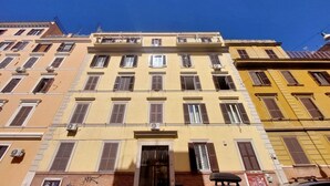A multi-story building with a central entrance, balconies, and air conditioning units. - Piazza Vittorio - Recently redecorated apartment for 4 (Roma)