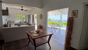 Eine Küche mit Essbereich, Deckenventilator und Blick ins Freie.