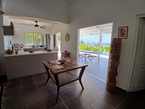 Eine Küche mit Essbereich, Deckenventilator und Blick ins Freie.