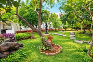 A well-maintained garden with a variety of plants, a statue, and a stone pathway. - Akshaya Bungalow Coimbatore (Coimbatore)