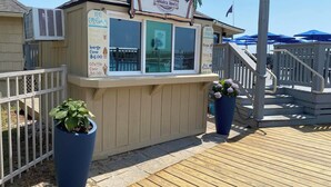 A small ice cream stand with a sign for Jamaica Mon'z, featuring a palm tree design. - Ocean View- Diamond Level- Admiral's Row A4-Professionally Managed by HHIB&T Vacation Rentals (Hilton Head Island)
