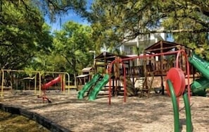 Ein Spielplatz mit Rutschen und Klettergerüsten.