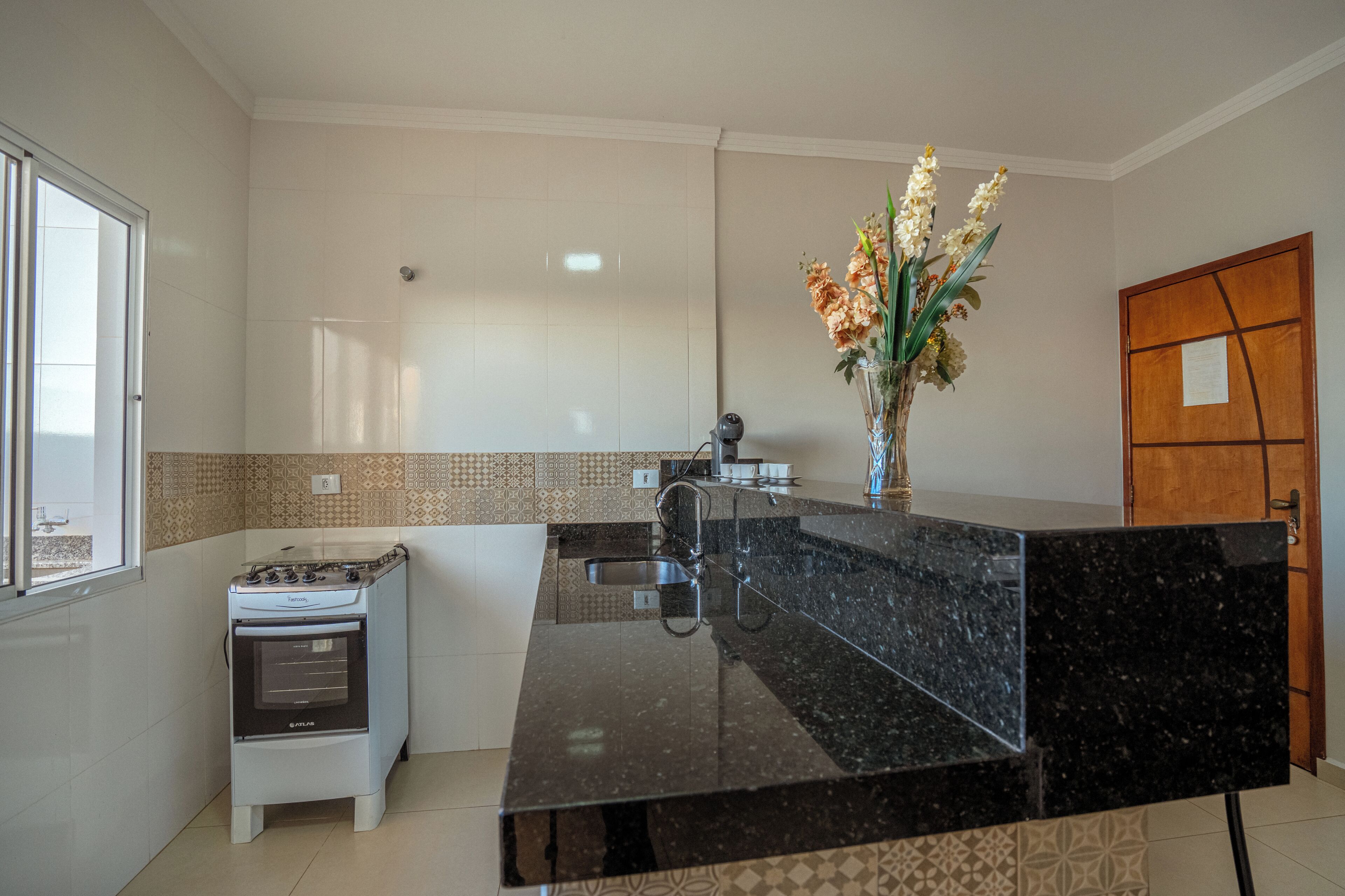 A kitchen with a stove, sink, and a large island.