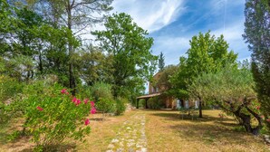A stone pathway leading to a rustic house surrounded by trees and shrubs. - Guest Room 'La Fenière' with Shared Pool, Garden & Summer Kitchen, Wi-Fi (Carcès)
