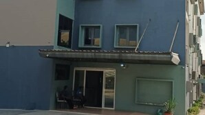 A multi-story building with a flat roof, a covered entrance, and a visible garage door.