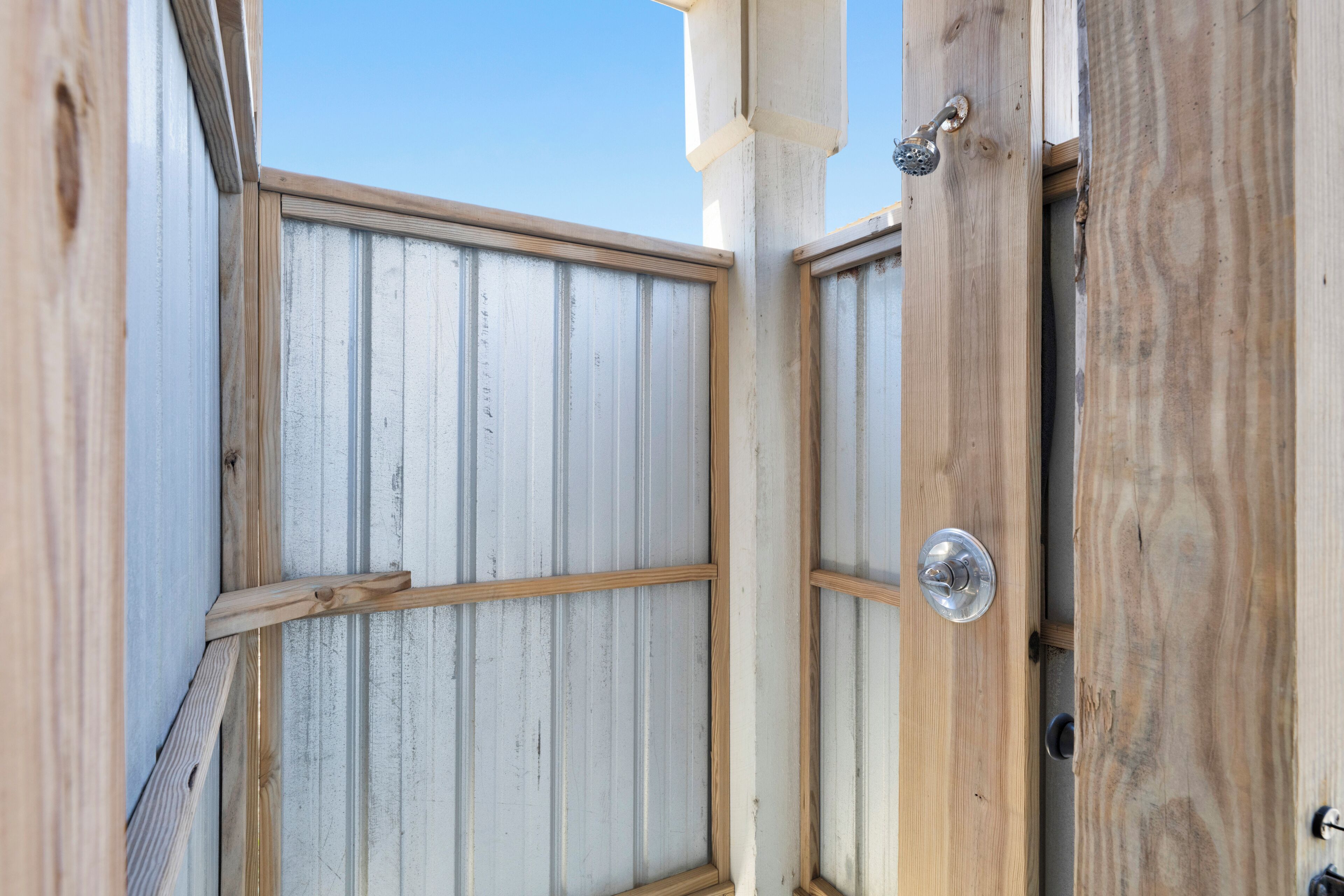 Une porte en bois avec une poignée en métal, un loquet en métal et un cadre en bois.