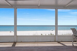 Een overdekt terras met uitzicht op het strand.