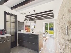 A modern kitchen with dark cabinetry, a chalkboard, and a view to the outdoor patio. - House with garden, 4 adults 1 child (Pleurtuit)