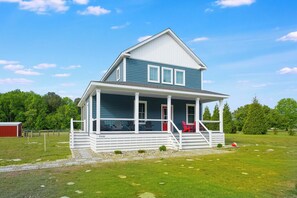 A two-story house with a porch, a red door, and a number '33600' on the side.