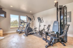 A home gym with various exercise equipment, including treadmills, an elliptical, and a circuit trainer. - Ocean View Luxury Olivia Beach Home, Top-Deck Hot Tub! (Lincoln City)