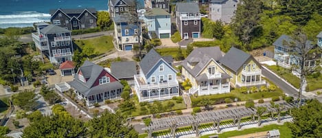 A coastal residential area with houses featuring balconies, a playground, and a view of the ocean.