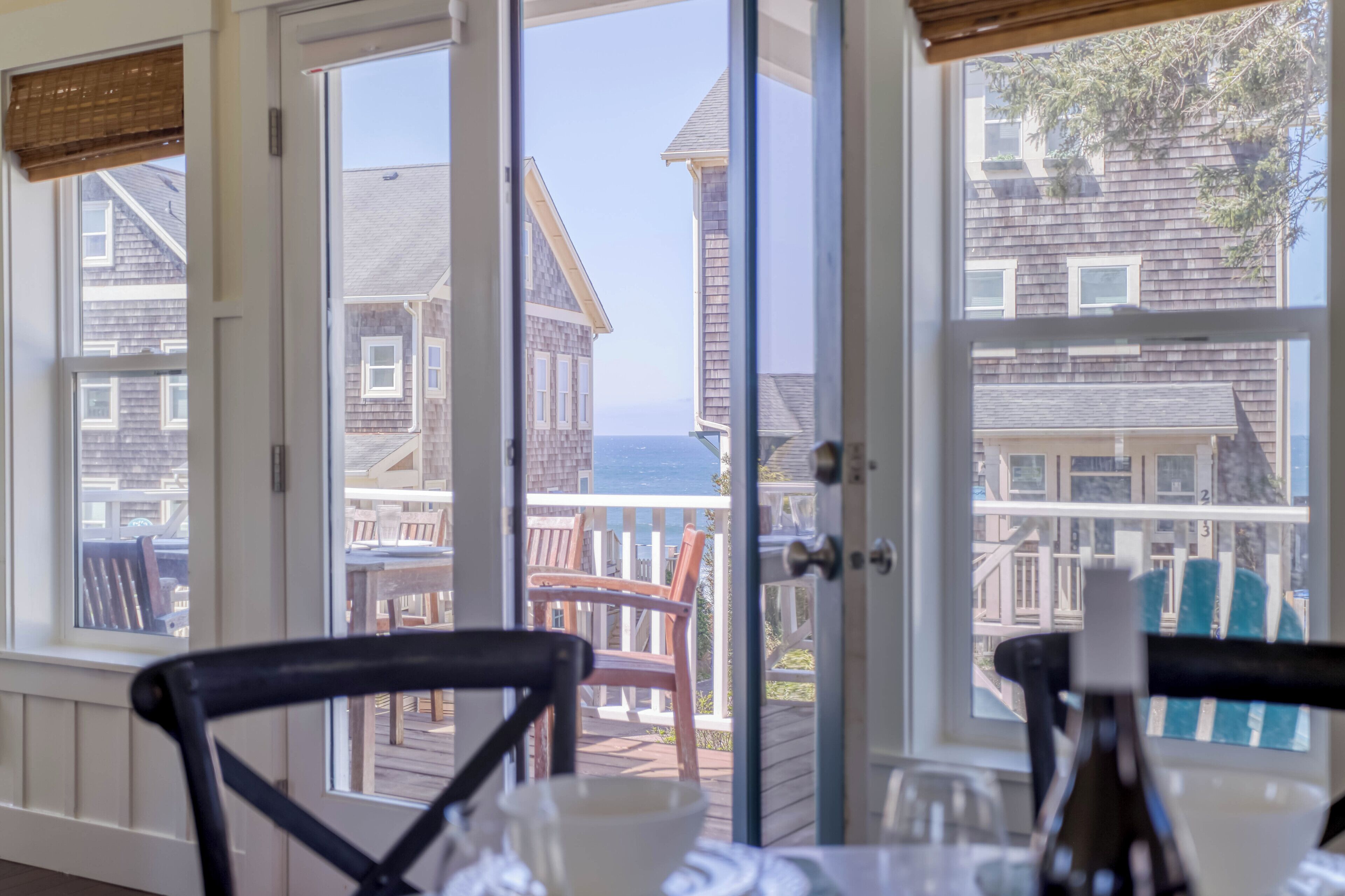 Coastal charm framed by classic architecture—your seaside getaway awaits just beyond the balcony, where ocean breezes meet weathered shingles and endless blue horizons.