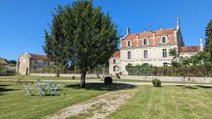A large, historic building with a red-tiled roof, surrounded by a well-maintained lawn and a tree. - The Chestnut (Chadurie)