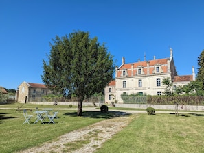 A large, historic building with a red-tiled roof, surrounded by a well-maintained lawn and a tree. - The Chestnut (Chadurie)