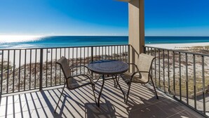 A balcony with a table and chairs overlooking a beach. - Phoenix X 508 1 Bedroom Condo (Orange Beach)